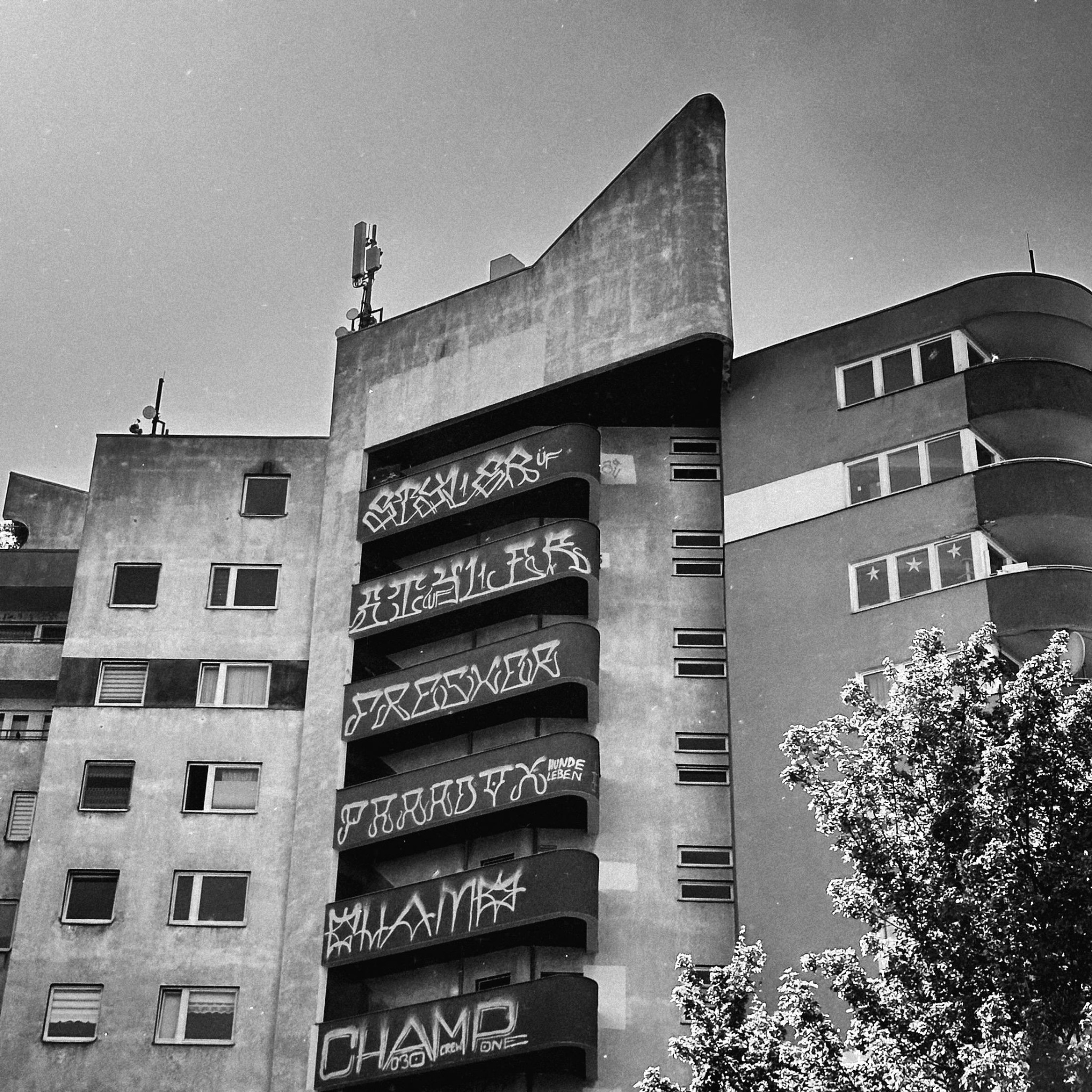 Graffiti-covered apartment building photographed from below