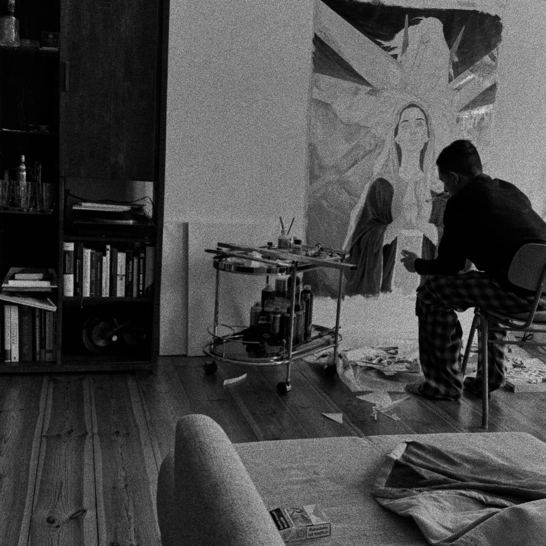Artist working in a studio before a large unfinished painting