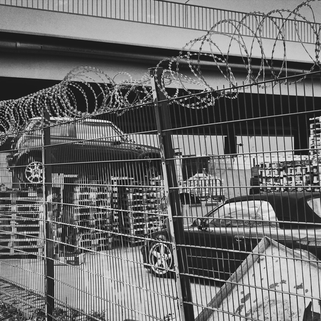 Vehicles behind industrial fencing and coils of razor wire